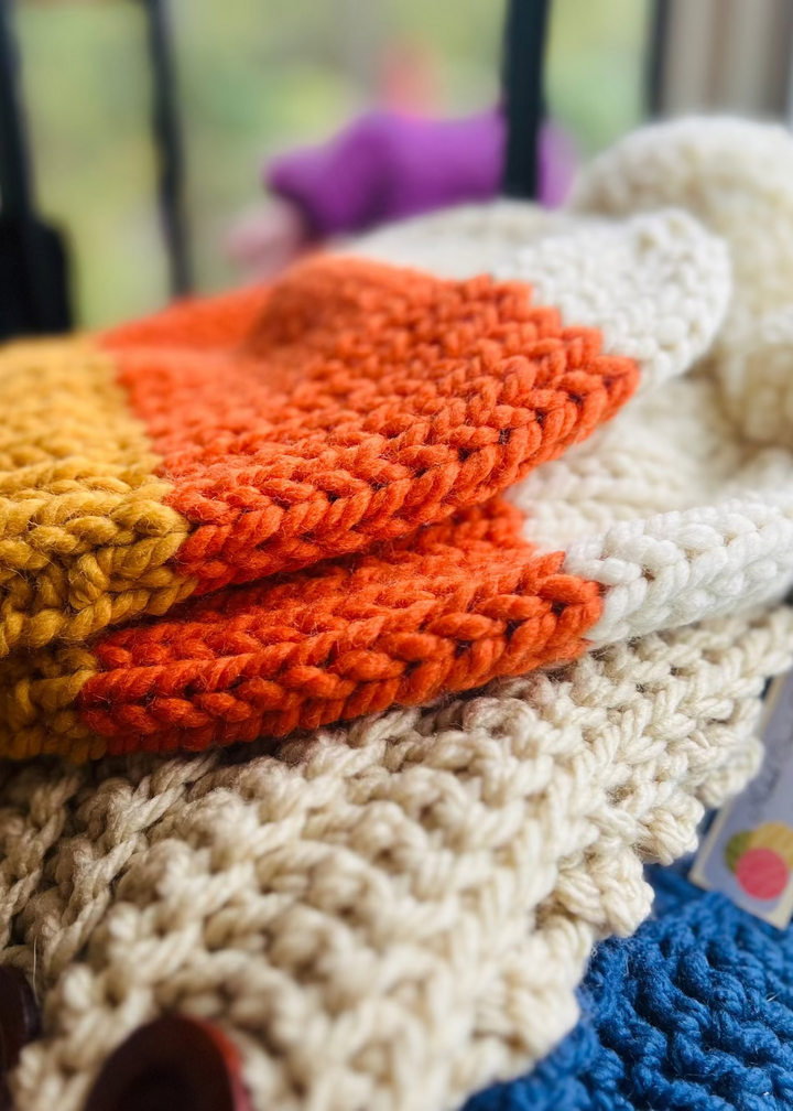 Stack of colorful knitted hats in fall and seasonal colors